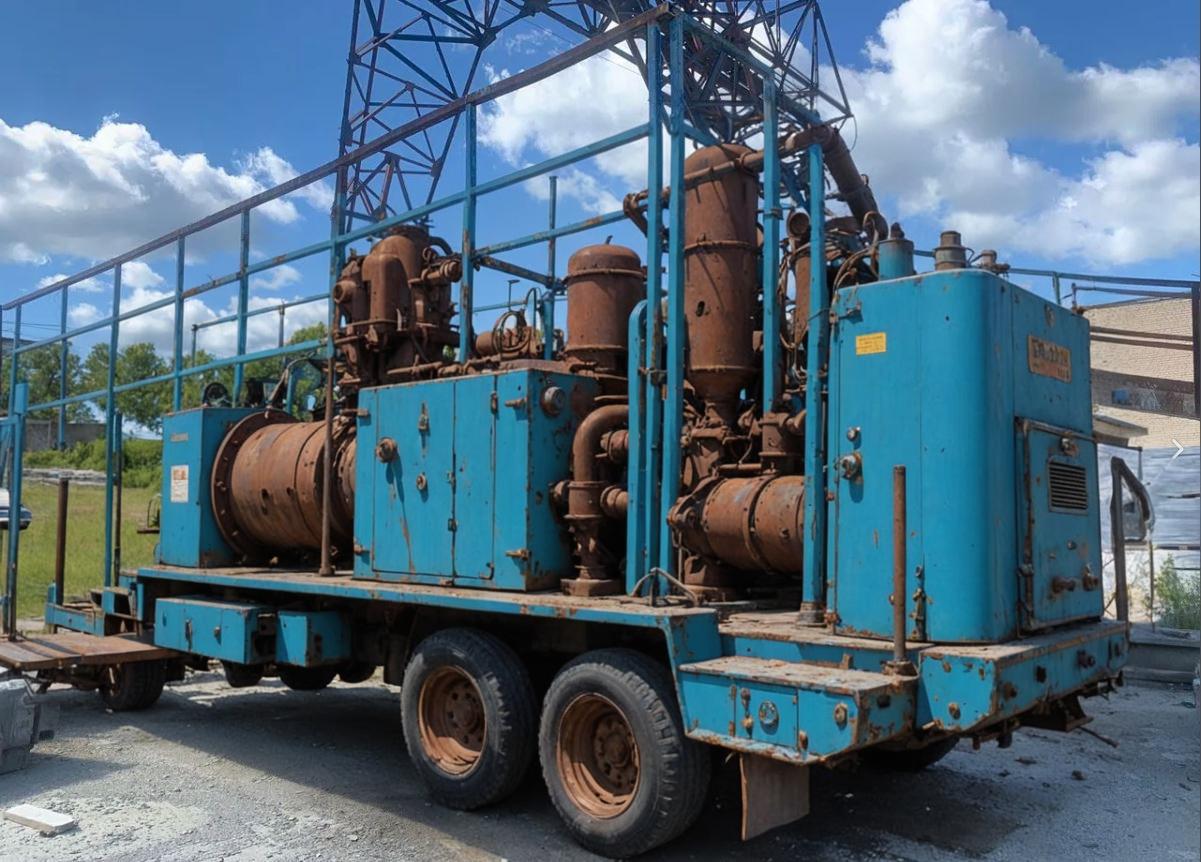 Cette image met en scène une machine robuste, une grande unité industrielle bleue montée sur un plateau de camion, dotée de diverses pièces rouillées et de tuyaux, évoquant un sentiment d'industrie lourde et de fonctionnalité. C'est un exemple de la façon dont l'outil 'Inpaint' peut remplacer ou améliorer des éléments spécifiques d'une image, en les intégrant de manière fluide dans la scène.